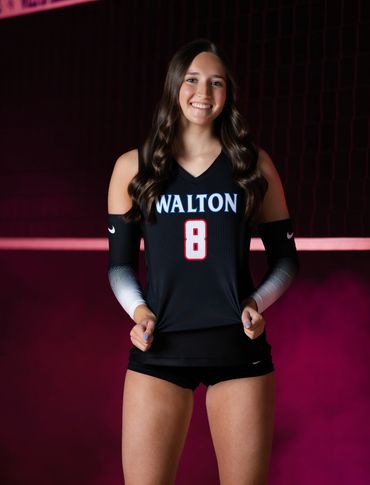Female volleyball player in Walton jersey number 8 poses confidently.