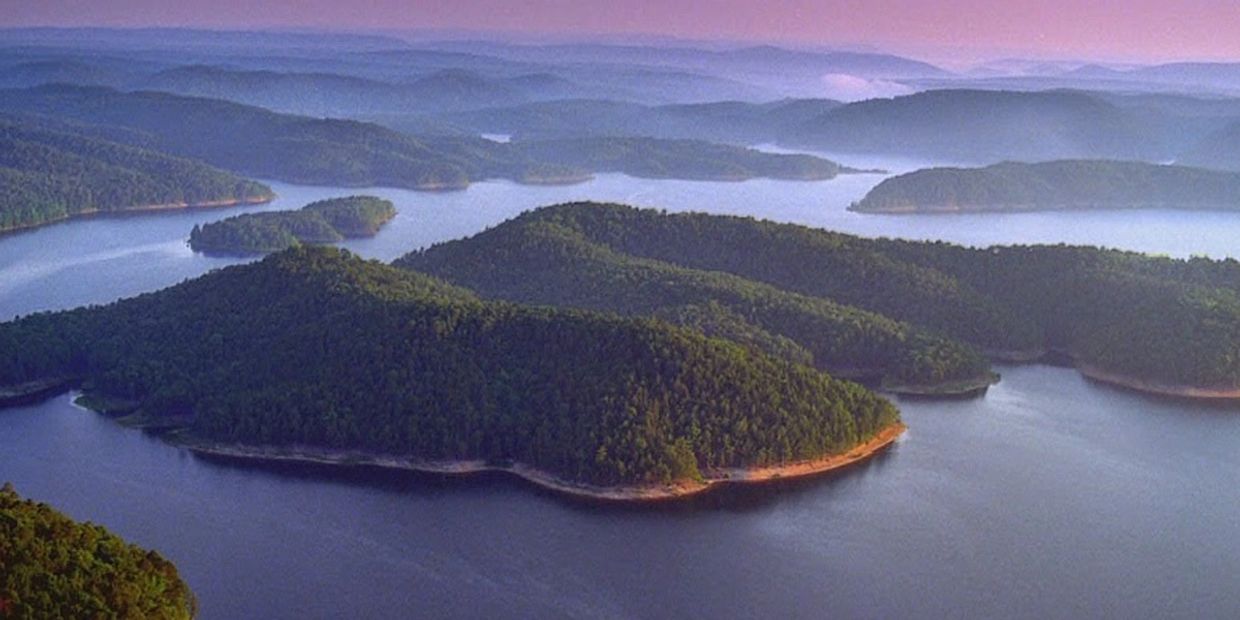 Aerial view of forested islands in a calm lake during sunset.