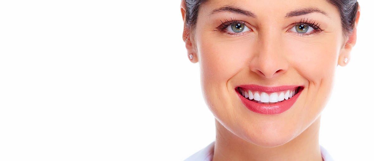 Close-up of a smiling woman with bright eyes and white teeth.
