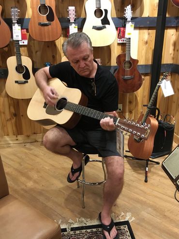 John Singer playing a 12-string acoustic electric Martin guitar