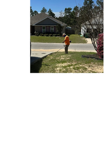Man in an orange shirt trimming grass near a driveway under sunny sky.