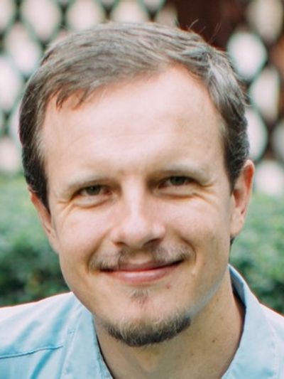 Smiling man with short hair and light facial hair.