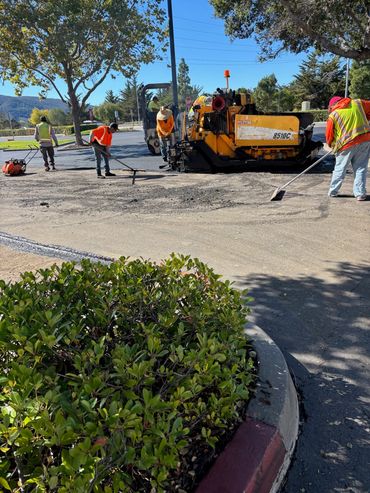 Integrous Paving crew operating paving equipment while installing fresh asphalt on a roadway.