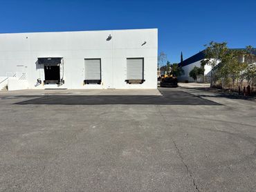 Repaired asphalt section in a parking lot by Integrous Paving.
