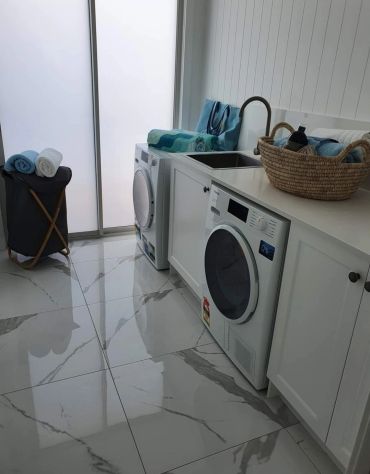 Modern laundry room with washing machines and towels.