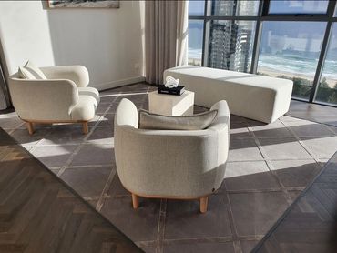 Modern living room with beige furniture and ocean view.