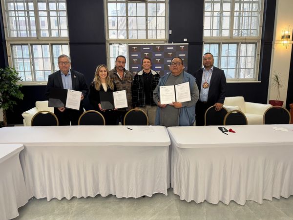 Business professionals in suits seated at a meeting table