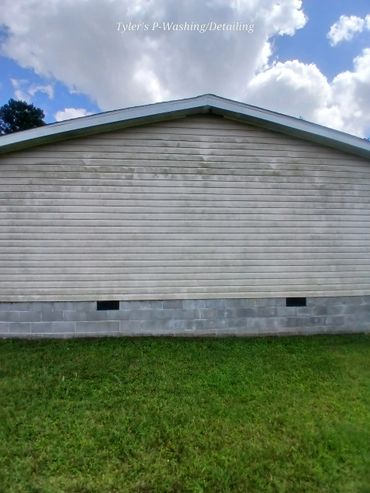 Side of a house partially cleaned, showing a clear contrast.
