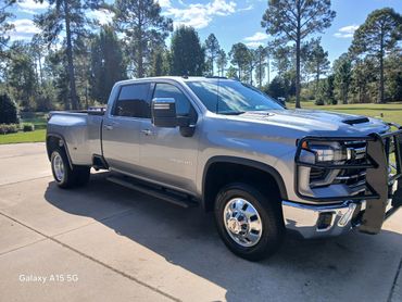 A silver heavy-duty 3500 HD pickup truck parked on a driveway.