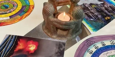 Candle holder sculpture surrounded by colorful spiral drawings and photos.