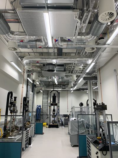 Industrial laboratory with advanced machinery and exposed ductwork ceiling.