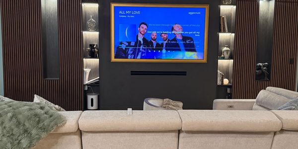 Modern living room with a large TV and beige sofa.
