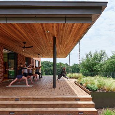 Group doing yoga on a wooden deck.