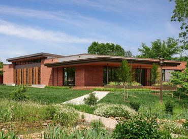 Modern brick building with lush green landscaping.