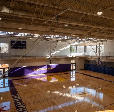 Empty indoor basketball court with Chatham Hall text.