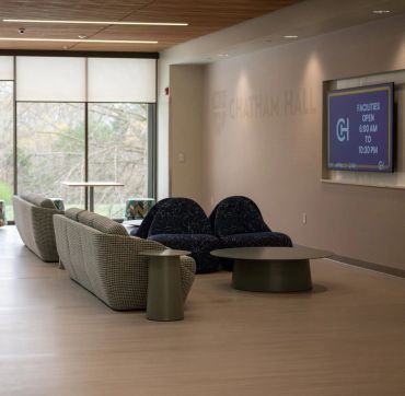 Modern lounge area with sofasa and a TV screen.