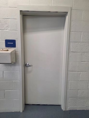 Interior of an empty industrial workshop with blue roller doors.