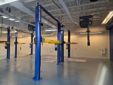 Empty auto repair shop with blue rotary lifts.