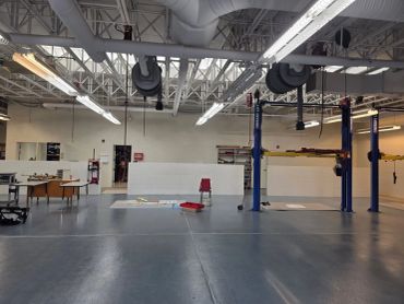 Empty automotive workshop with vehicle lifts and workstations.