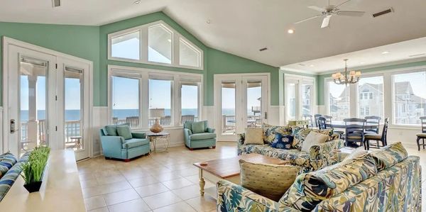 Bright beach house living room with ocean views and floral furniture.