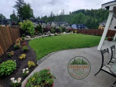 Well-maintained backyard with lush lawn, flower beds, and patio seating.