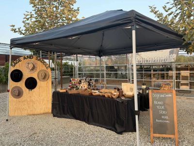 Sage and Saddle hat bar setup with hat display board and branding station