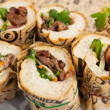 Close-up of delicious Vietnamese banh mi sandwiches wrapped in paper.
