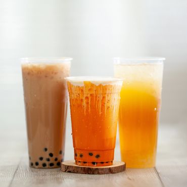Three refreshing iced bubble tea drinks with tapioca pearls.