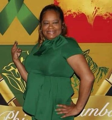 Woman in a green outfit posing confidently with a smile.