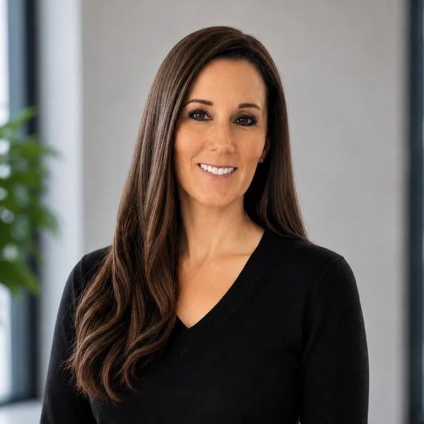 Smiling woman with long brown hair in a black top.