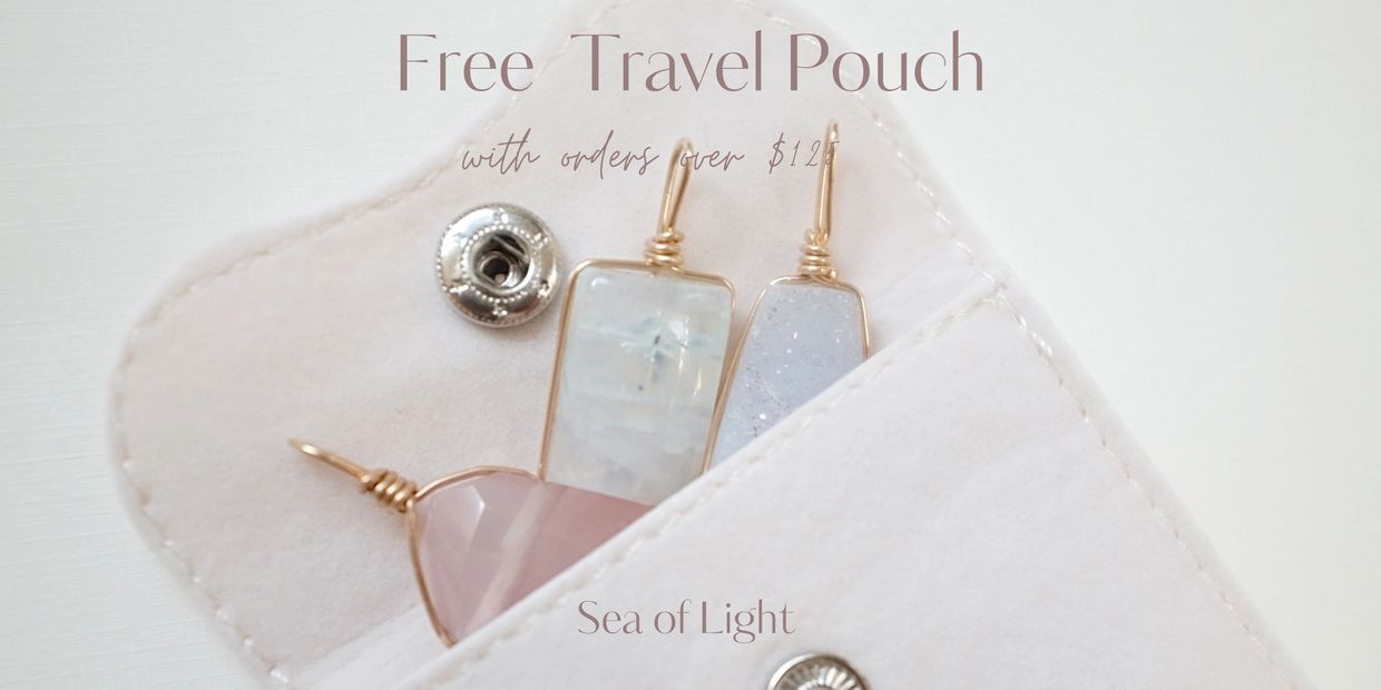 Three Crystal Pendants in a Beige Pouch. Text reads “Free Travel Pouch with orders over $125”