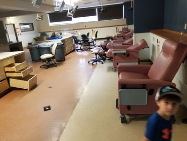 Medical beds, tanks, and equipment staged for removal in commercial building