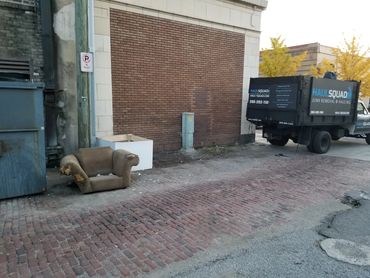 Trash, furniture, and bags set out for scheduled curbside junk removal