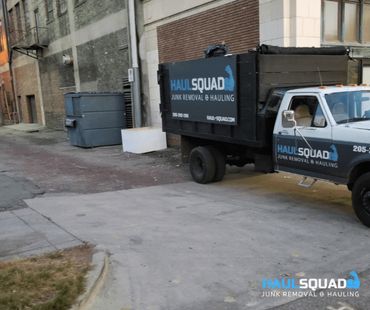 curbside junk pickup in progress outside a bimringham back alley