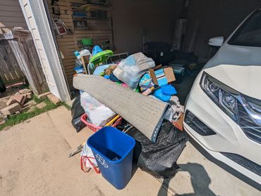 Overflowing junk pile with household items and boxes on residential curb