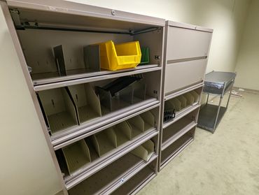 filing cabinet and cluttered shelves ready for removal with yellow file bin