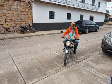 Man riding small motorcycle down a street in Degollado, Jalisco