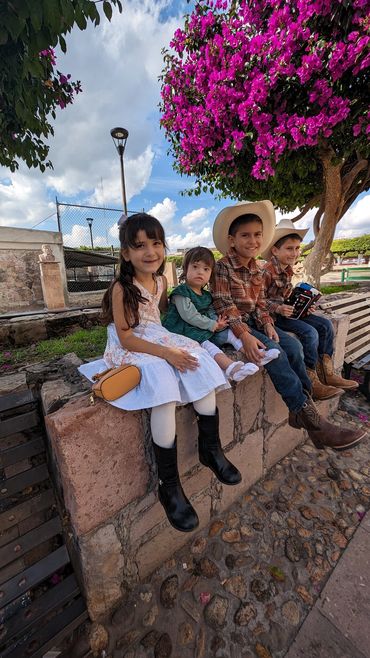 Hill family relaxing together on bench in Degollado town center