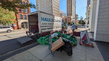 Downtown Birmingham office cleanout with Haul Squad truck and office furniture on the curb
