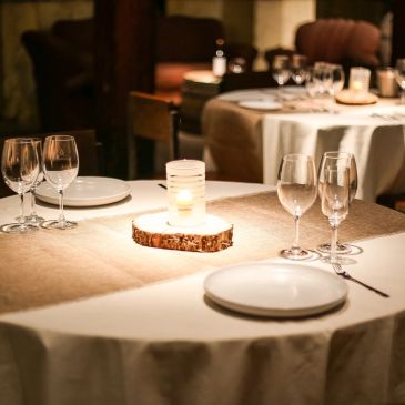 Elegant candlelit dining table set with wine glasses and plates.