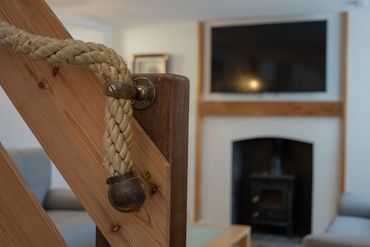 Little seaside touches, rustic rope handrail on staircase along with wooden handrail.