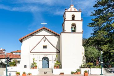 Historic white mission church with bell tower.