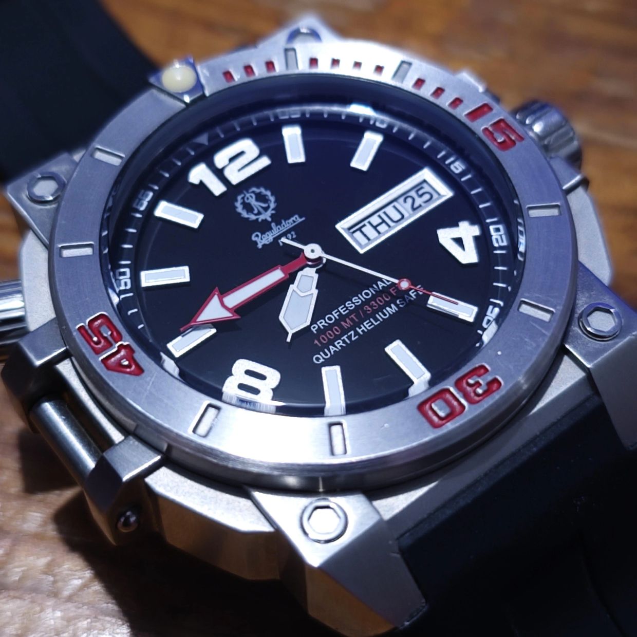 Close-up of a professional diver's wristwatch with a black dial and red accents.