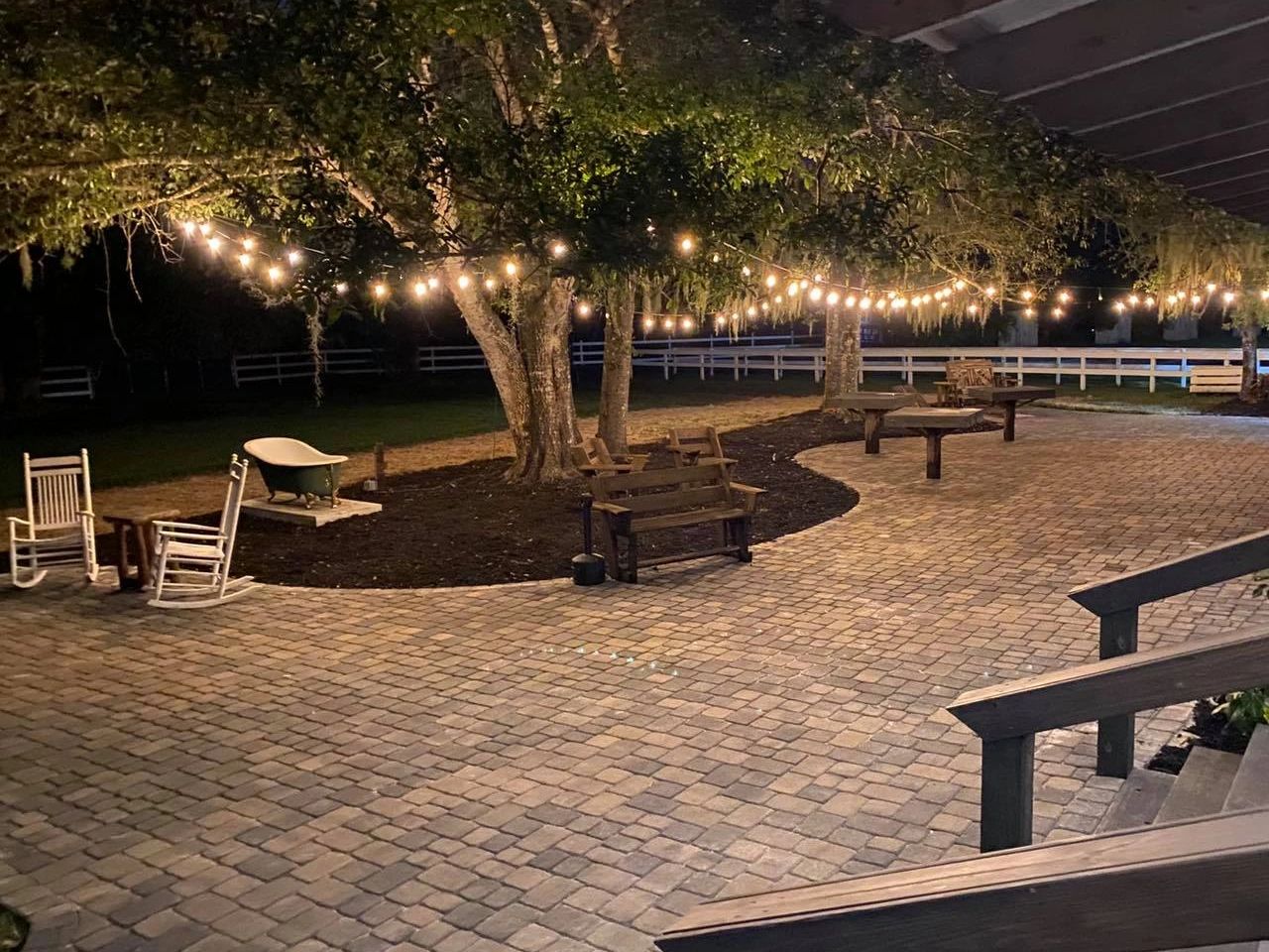 Outdoor patio with string lights and seating at night.