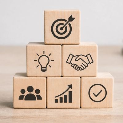 Wooden blocks with business icons symbolizing ideas, teamwork, growth, and success.
