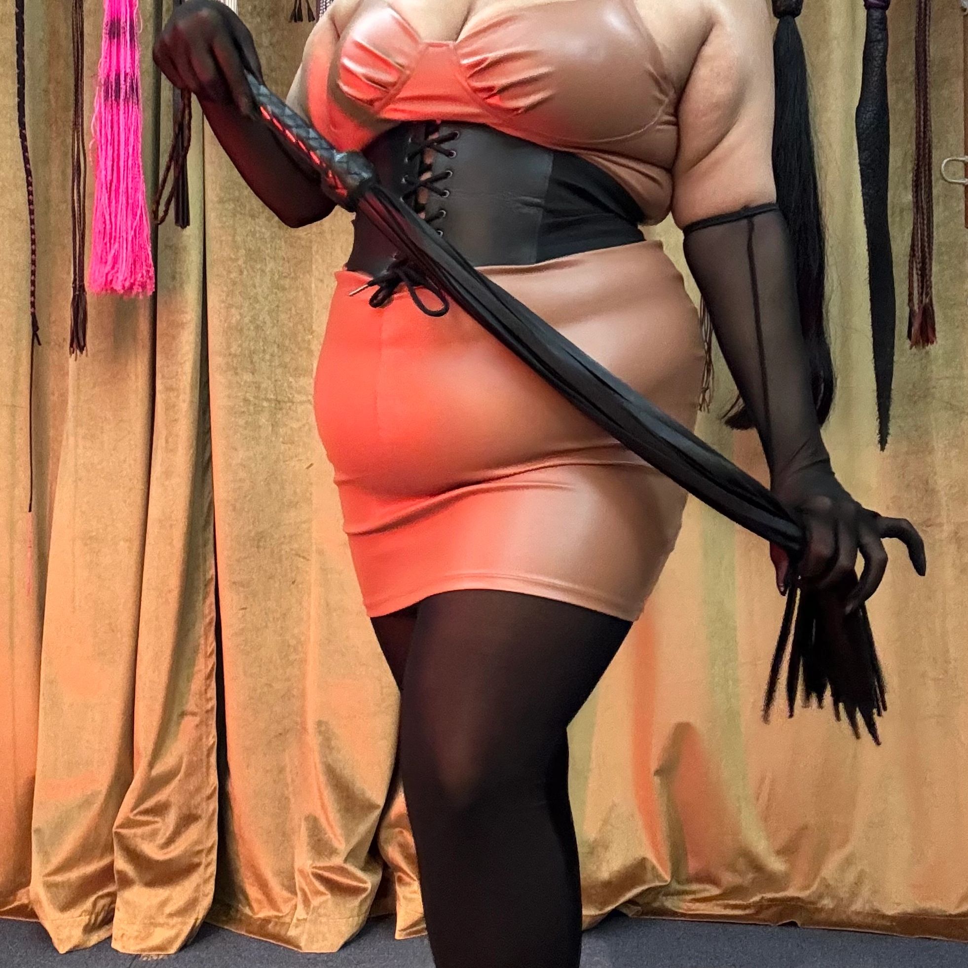 Person in sensual attire with black gloves and corset.