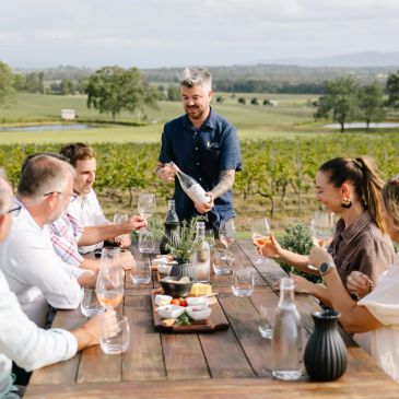 Group enjoying wine tasting outdoors.
