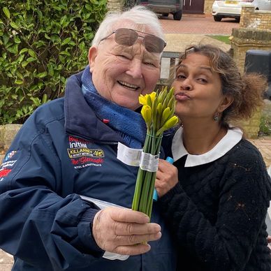 Picture of an artist and an elderly man holding a bouquet