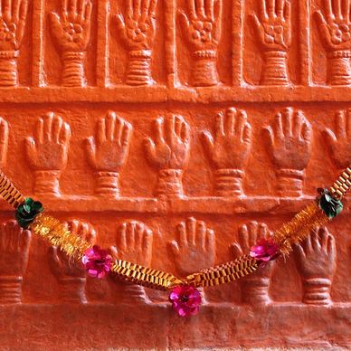 Small hands carved into a red stone