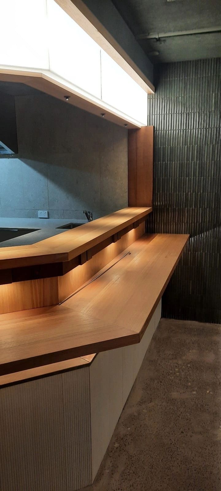 Minimalist wooden bar with ambient lighting.